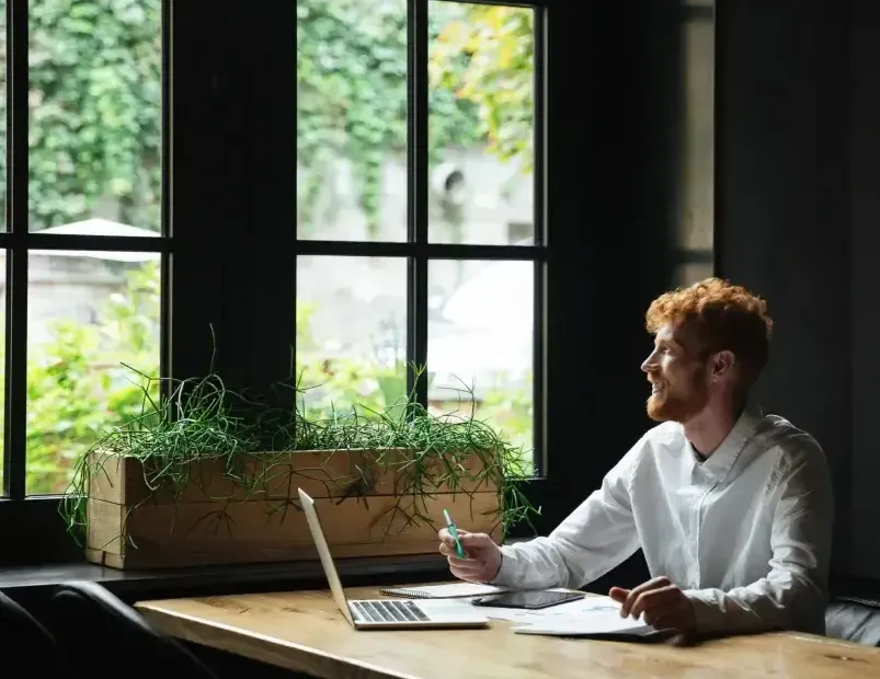 Reviewing business finances on a laptop by an office window